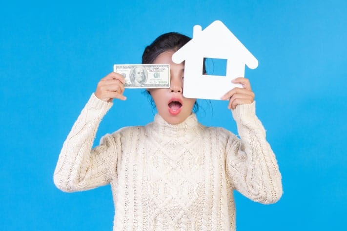 woman holding house symbol dollars save for your down payment