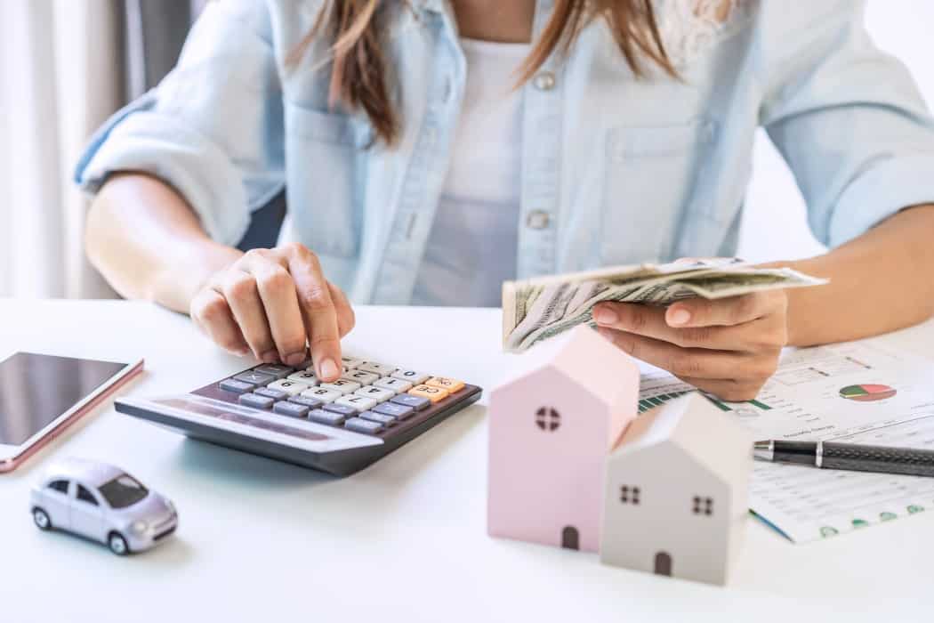 young woman calculating home expenses out of pocket expenses when buying a house